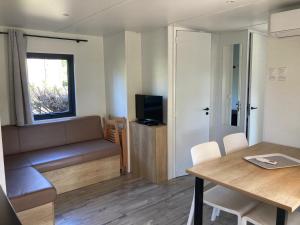 a small living room with a couch and a table at Mobil Home 6 personnes in Biscarrosse