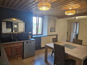 Una cocina con una mesa y un comedor. en Le moulinot, en Morteau
