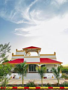 a house with a red roof and palm trees at Gift city farmhouse in Gandhinagar