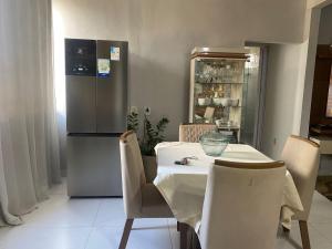 a kitchen with a table with chairs and a refrigerator at Villa Zilá in Vila Velha