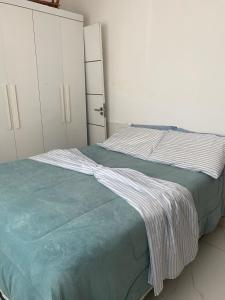 a bedroom with a bed with a striped blanket on it at Villa Zilá in Vila Velha