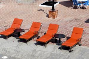 eine Gruppe orangefarbener Stühle und ein Tisch in der Unterkunft Hotel Hacienda Bugambilias La Paz in La Paz
