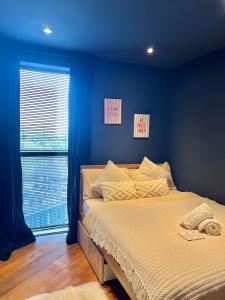 a bedroom with a bed with blue walls and a window at Casa Del Amor in London +14 photos