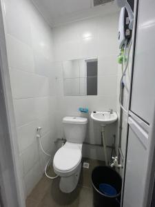 a small bathroom with a toilet and a sink at Hillside Suites in Ranau +9 photos