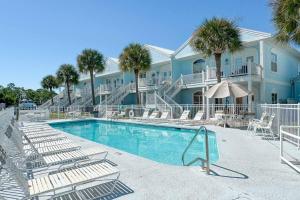 a resort with a swimming pool with chairs and palm trees at Charter Landing A10 in Orange Beach