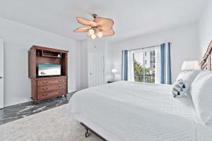 a white bedroom with a bed and a tv at Charter Landing A10 in Orange Beach +43 photos