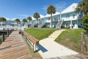 a large building with a wooden boardwalk and palm trees at Charter Landing A10 in Orange Beach