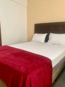 een slaapkamer met een groot bed met een rode deken bij Apartamento 3 quartos Bueno com 2 garagens in Goiânia