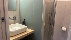 a bathroom with a white sink and a shower at FAZIO ROOMS Roma in Rome +6 photos