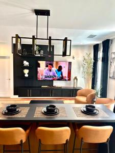 ein Wohnzimmer mit einem Tisch mit Stühlen und einem TV in der Unterkunft Free Parking, King Bed, 75 inch TV, and Luxury Stay in Atlanta