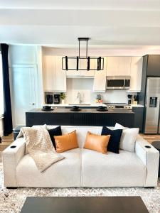 ein Wohnzimmer mit einer weißen Couch und einer Küche in der Unterkunft Free Parking, King Bed, 75 inch TV, and Luxury Stay in Atlanta