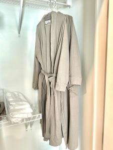 ein Bademantel, der an einer Stange in einem Schrank hängt in der Unterkunft Free Parking, King Bed, 75 inch TV, and Luxury Stay in Atlanta