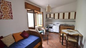 eine kleine Küche mit einem Sofa und einem Tisch in einem Zimmer in der Unterkunft Le Rose in Marina di Camerota