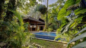 a house in the jungle with a swimming pool at Bodhi & Nirvana Houses in Talamanca