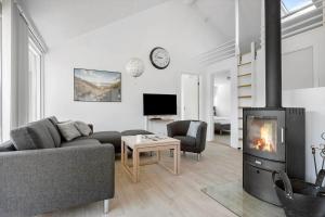 a living room with a couch and a fireplace at JB221-Brovst-Kronvildtvej-182 in Tranum
