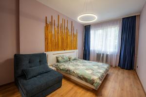 a bedroom with a bed and a chair at 1 minute to main Street & NDK & Free Parking in Sofia