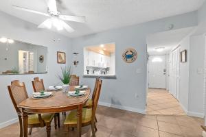 Gone Coastal l Ground Floor Condo l Steps to Beach في Anastasia Island: غرفة طعام ومطبخ مع طاولة وكراسي