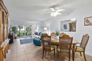 Gone Coastal l Ground Floor Condo l Steps to Beach في Anastasia Island: غرفة طعام وغرفة معيشة مع طاولة وكراسي