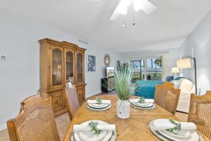 Gone Coastal l Ground Floor Condo l Steps to Beach في Anastasia Island: غرفة طعام مع طاولة وكراسي وأريكة