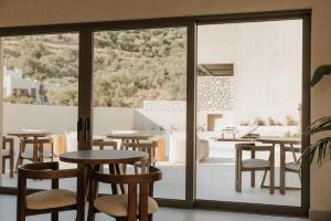 a restaurant with tables and chairs and sliding glass doors at AMÉNTE Mindful Suites in Plakias
