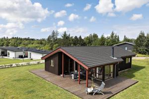 a small house with a wooden deck in a yard at JB188-Fjerritslev-Kollerup-Klitvej-163 in Fjerritslev