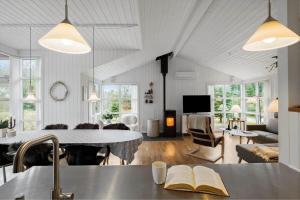 Una cocina y una sala de estar con una mesa y un sofá. en JB231-Fjerritslev-Poppelvej-2, en Fjerritslev