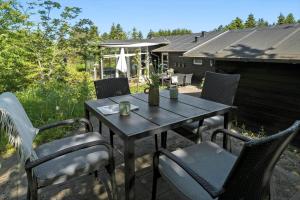 Una mesa y sillas de madera en un patio. en JB231-Fjerritslev-Poppelvej-2, en Fjerritslev