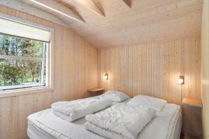 ein Schlafzimmer mit einem Bett mit weißer Bettwäsche und einem Fenster in der Unterkunft JB251 Fjerritslev - Egevej 5 in Fjerritslev