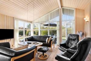 ein Wohnzimmer mit schwarzen Ledermöbeln und einem TV in der Unterkunft JB251 Fjerritslev - Egevej 5 in Fjerritslev