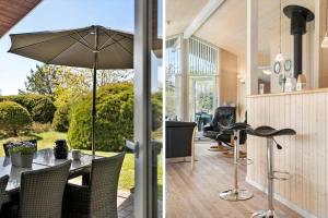 ein Esszimmer mit einem Tisch und einem Sonnenschirm in der Unterkunft JB251 Fjerritslev - Egevej 5 in Fjerritslev