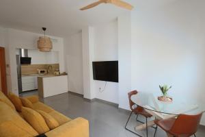 a living room with a couch and a glass table at Castell Beach - Sea front - parking - swimming pool in Castell de Ferro
