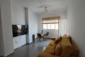 a living room with a couch and a flat screen tv at Castell Beach - Sea front - parking - swimming pool in Castell de Ferro