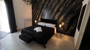 une chambre avec un lit noir avec deux oreillers blancs dans l'établissement Suite del Corso, à Ficarazzi