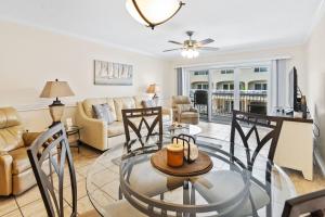 a living room with a glass table and chairs at Walk to Beach, Pool & Flagler! Relaxed Condo with Balcony & Full Kitchen in Chicken Island