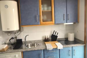 a kitchen with blue cabinets and a sink at Casa do Balneario in Arnoia