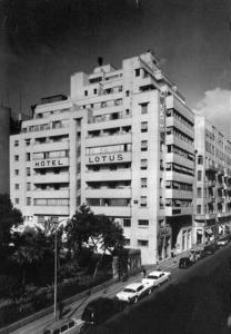 um grande edifício branco com carros estacionados em frente em Lotus Hotel Cairo em Cairo