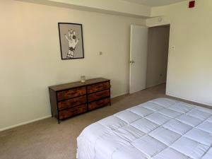 a bedroom with a white bed and a wooden dresser at Modern 1br Retreat In Elkins Park - Long Term in Jenkintown +10 photos