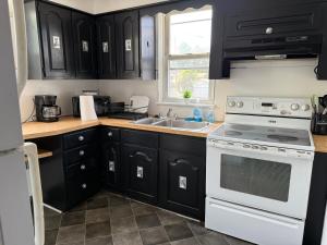 a kitchen with black cabinets and a white stove top oven at 1-bedroom Apartment In Rockledge in Rockledge