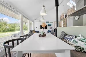 ein Wohnzimmer mit einem weißen Tisch und Stühlen in der Unterkunft JB752 Brovst - Kronvildtvej 210 in Tranum + 29 Fotos