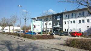 a parking lot with cars parked in front of a building at Hotel Thannhof 24h Check In in Schweitenkirchen