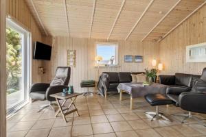 een woonkamer met een bank en stoelen bij JB230-Frostrup-Grabakkevej-4 in Lild Strand