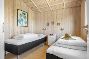 twee bedden in een kamer met houten wanden bij JB230-Frostrup-Grabakkevej-4 in Lild Strand