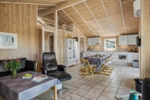 een keuken en woonkamer met een tafel en stoelen bij JB230-Frostrup-Grabakkevej-4 in Lild Strand