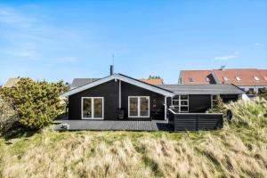 een zwart huis met een terras op het strand bij JB230-Frostrup-Grabakkevej-4 in Lild Strand