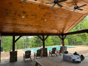 a wooden pavilion with chairs and a swimming pool at The Overlook at Lake James in Nebo +34 photos