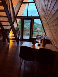 a wooden table in a room with a large window at A Frame Halmeag in Hălmeag