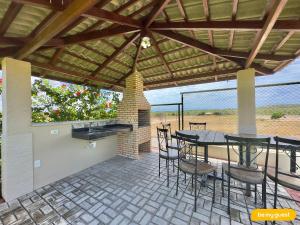a patio with a table and chairs and a fireplace at Clube Mirante do Iguape in Aquiraz