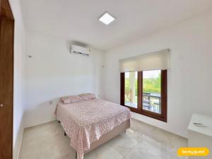a white bedroom with a bed and a window at Clube Mirante do Iguape in Aquiraz +39 photos