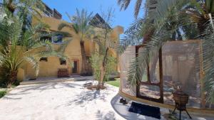 an exterior view of a house with palm trees at Spellbound in Siwa in Siwa