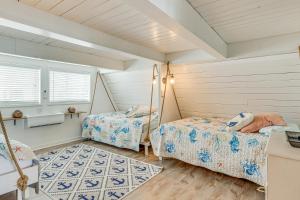 two beds in a room with two windows at Unique A-Frame Beach House The Beacon at OIB in Ocean Isle Beach